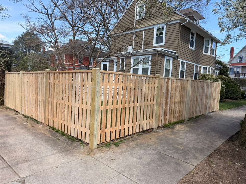 Open-picket wood fence corner, New England suburb