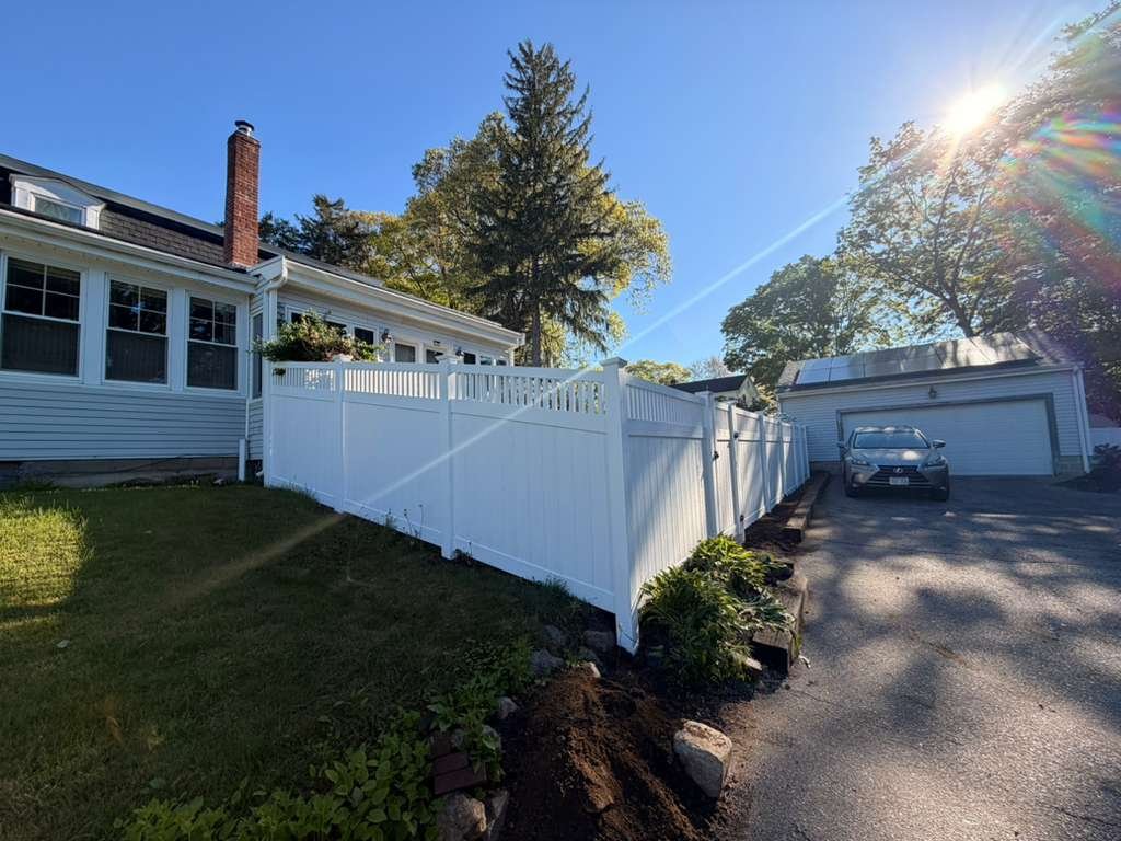 White vinyl fence with lattice top along driveway