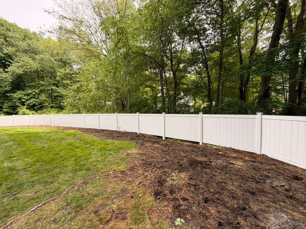 White vinyl privacy fence, curved backyard installation